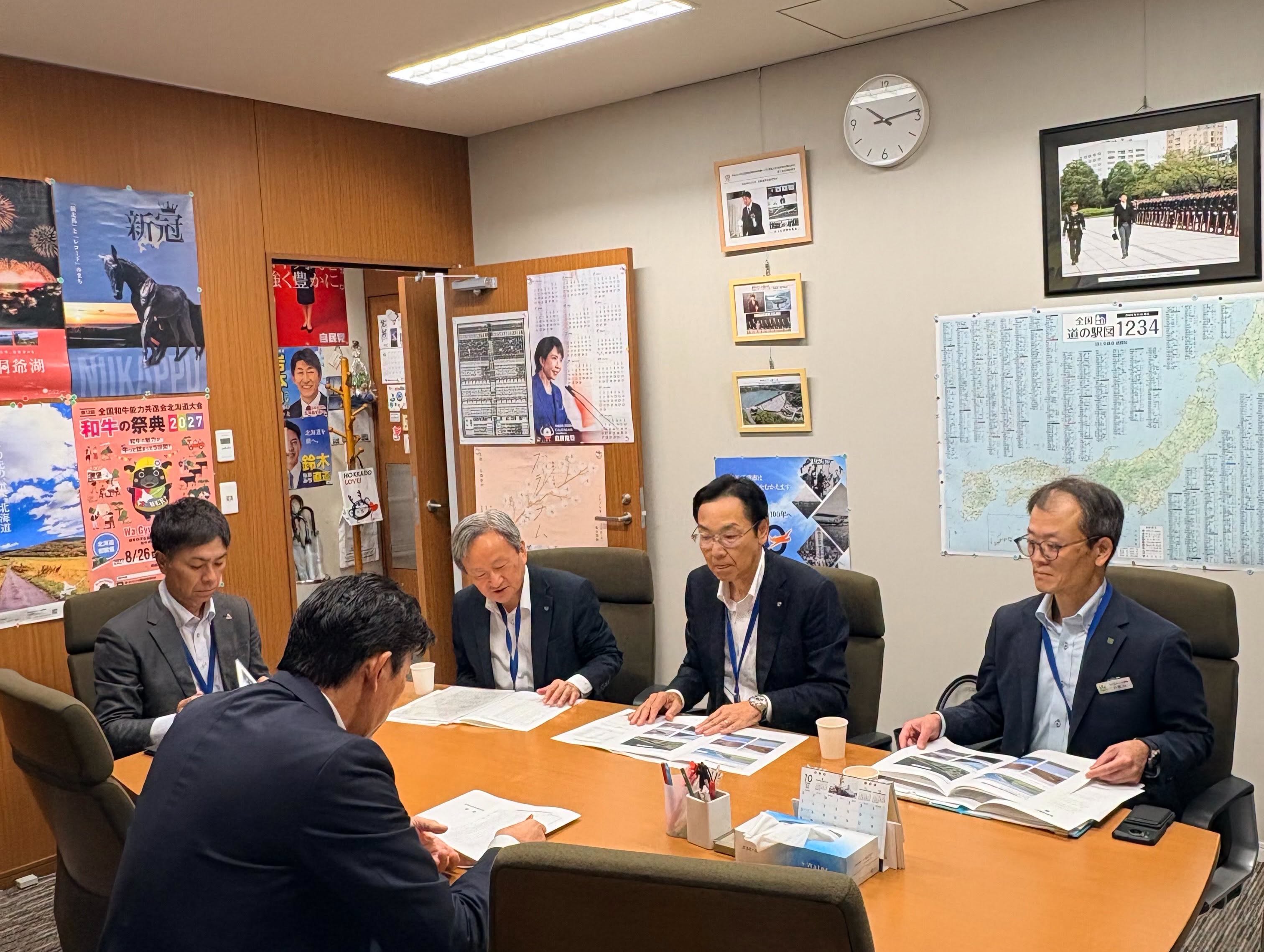関係者が会議テーブルを囲み、資料を確認している様子