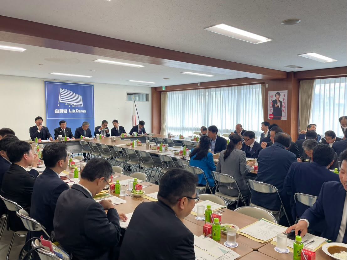 自民党酪政会の会議全景。多くの出席者が向かい合って着席している